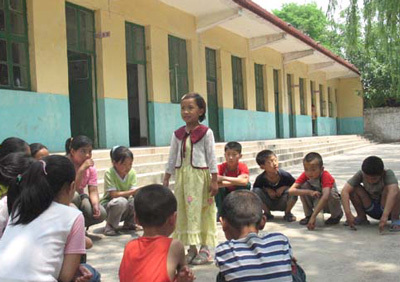 耿村小学的学生们在课余围成一圈讲故事情景